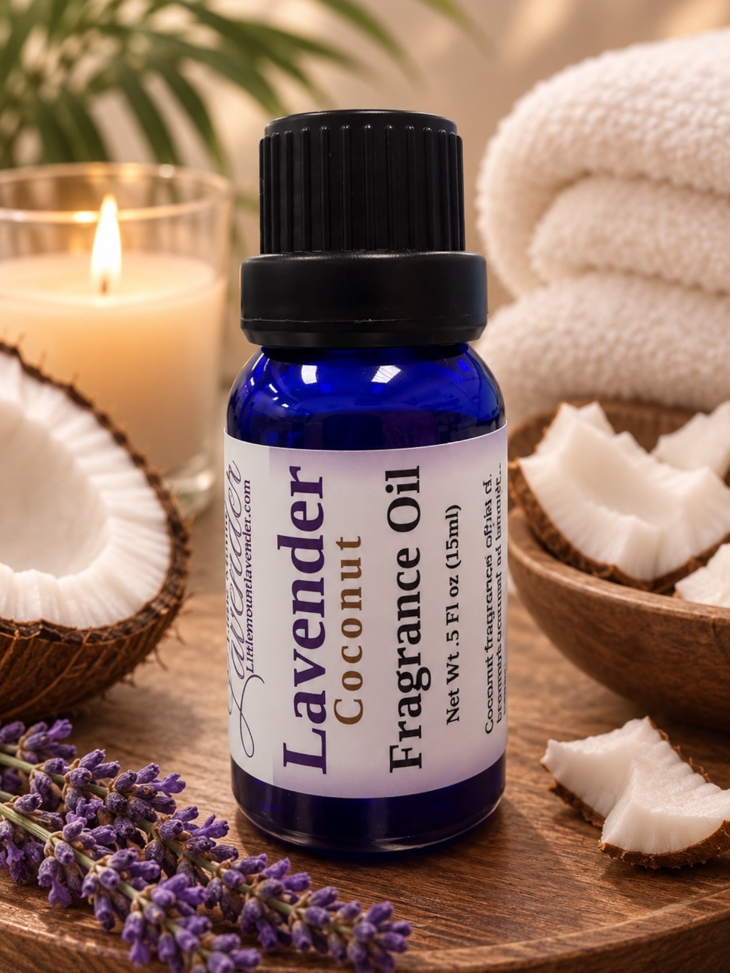 Little Mount Lavender coconut fragrance oil in a deep blue glass bottle with a sprig of fresh lavender flowers