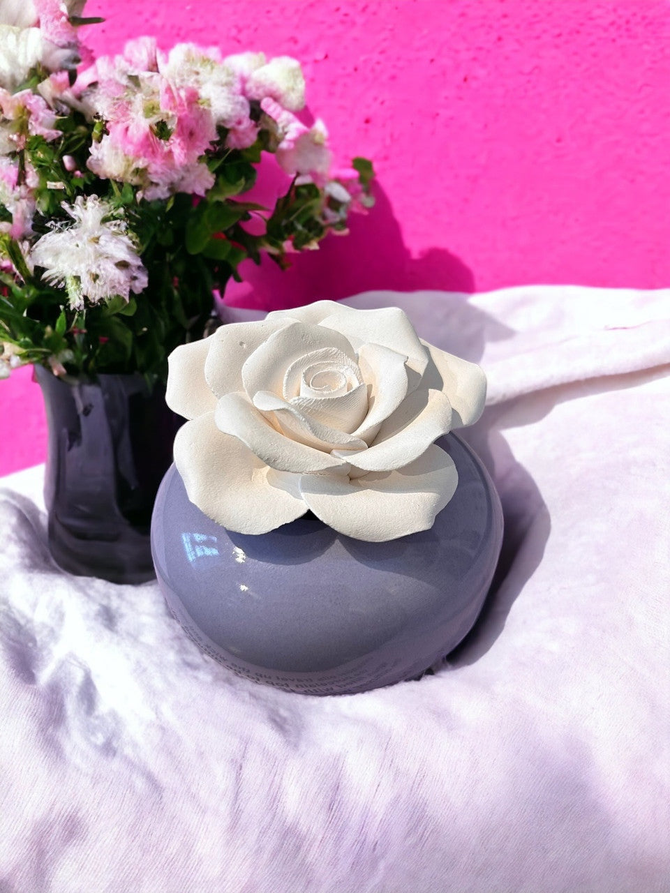 Little Mount Lavender rose porcelain essential oil diffuser with a cream flower top on a purple ceramic base.
