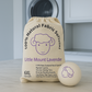 Bag of Little Mount Lavender natural fabric softener with a softener ball on a laundry room floor.