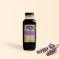 Bottle of LML Lavender Simple Syrup on a marble surface with a beige background