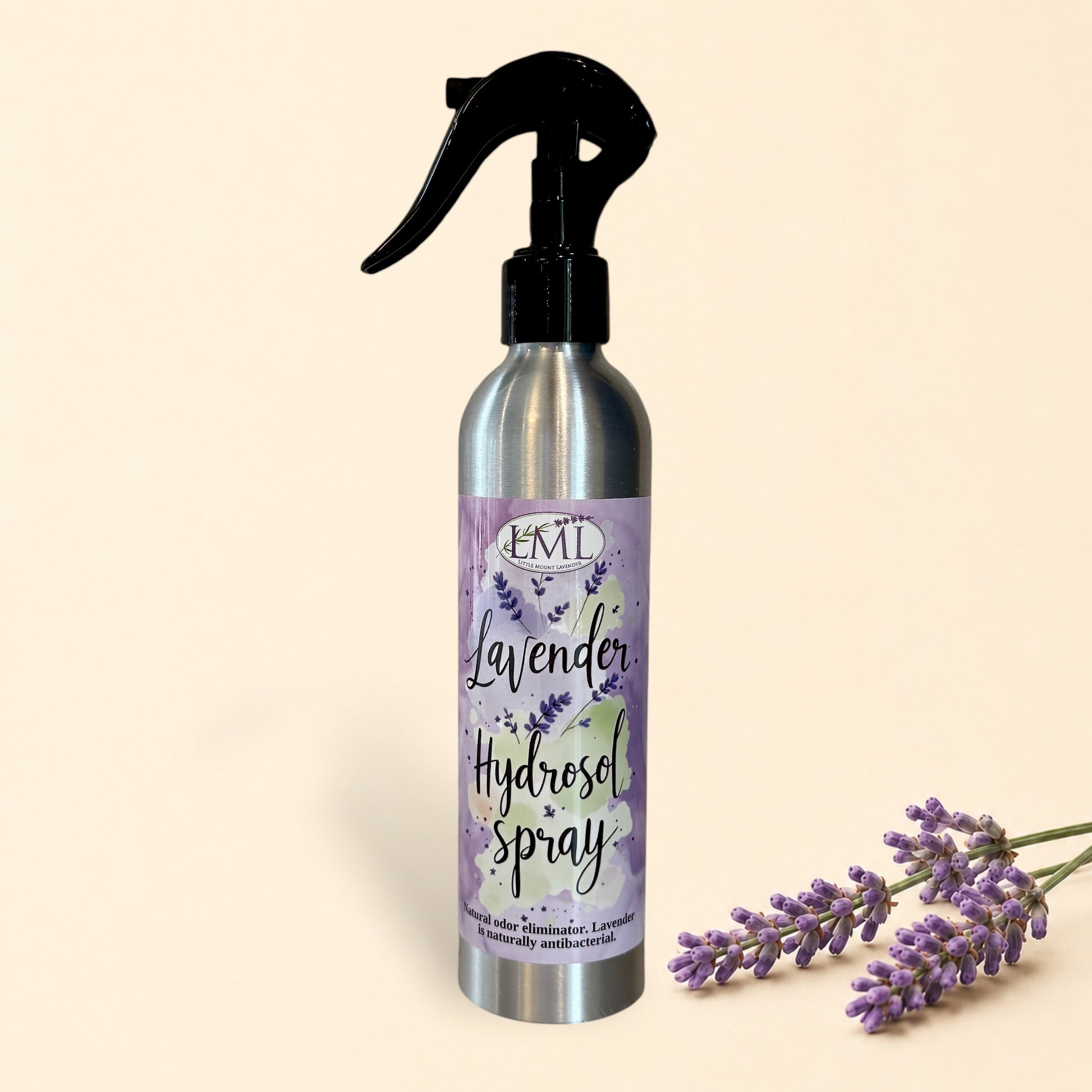 Silver spray bottle with lavender hydrosel label on a tiled wall background