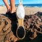 Little Mount Lavender 4 in 1 bamboo foot brush with pumice stone and exfoliating file on a sandy beach background