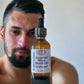 Little Mount Lavender beard oil in amber glass bottle with dropper, held by a man with a well-groomed beard.