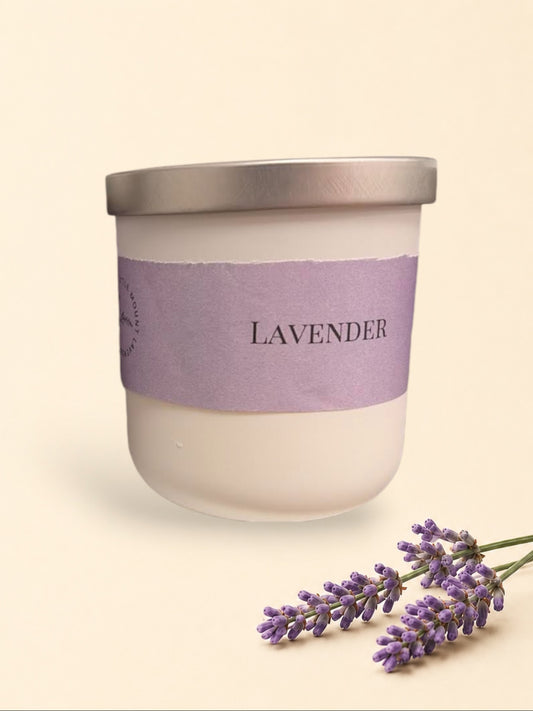 Little Mount Lavender scented candle in a matte black jar with a silver lid and lavender sprigs on a cream background.