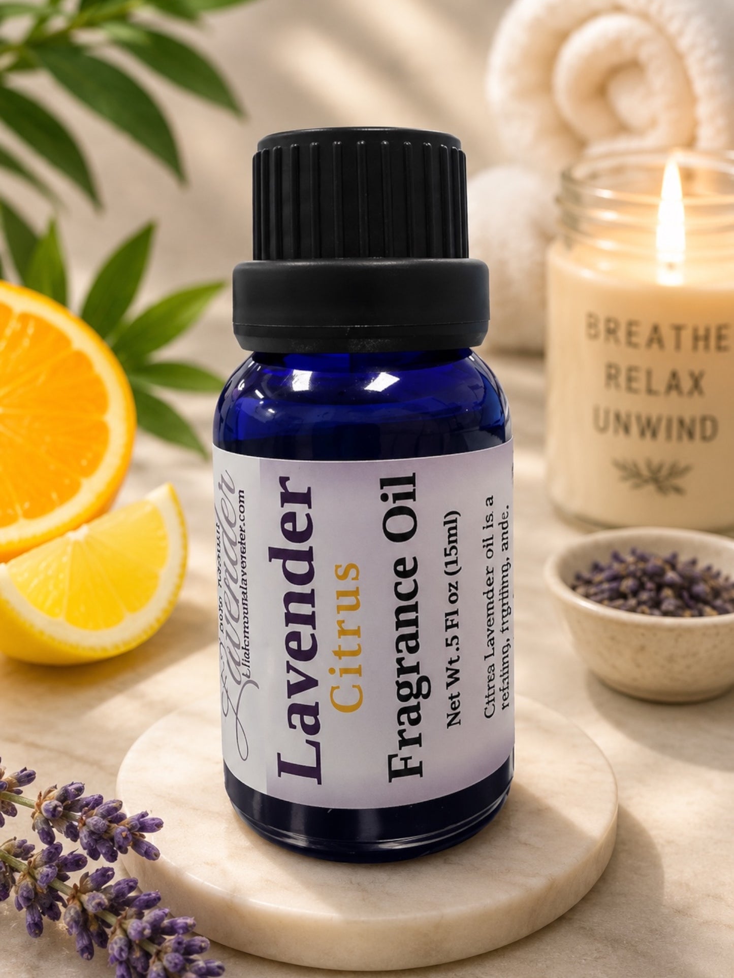 Little Mount Lavender fragrance oil in a cobalt blue glass bottle with a dropper cap, next to fresh lavender sprigs.
