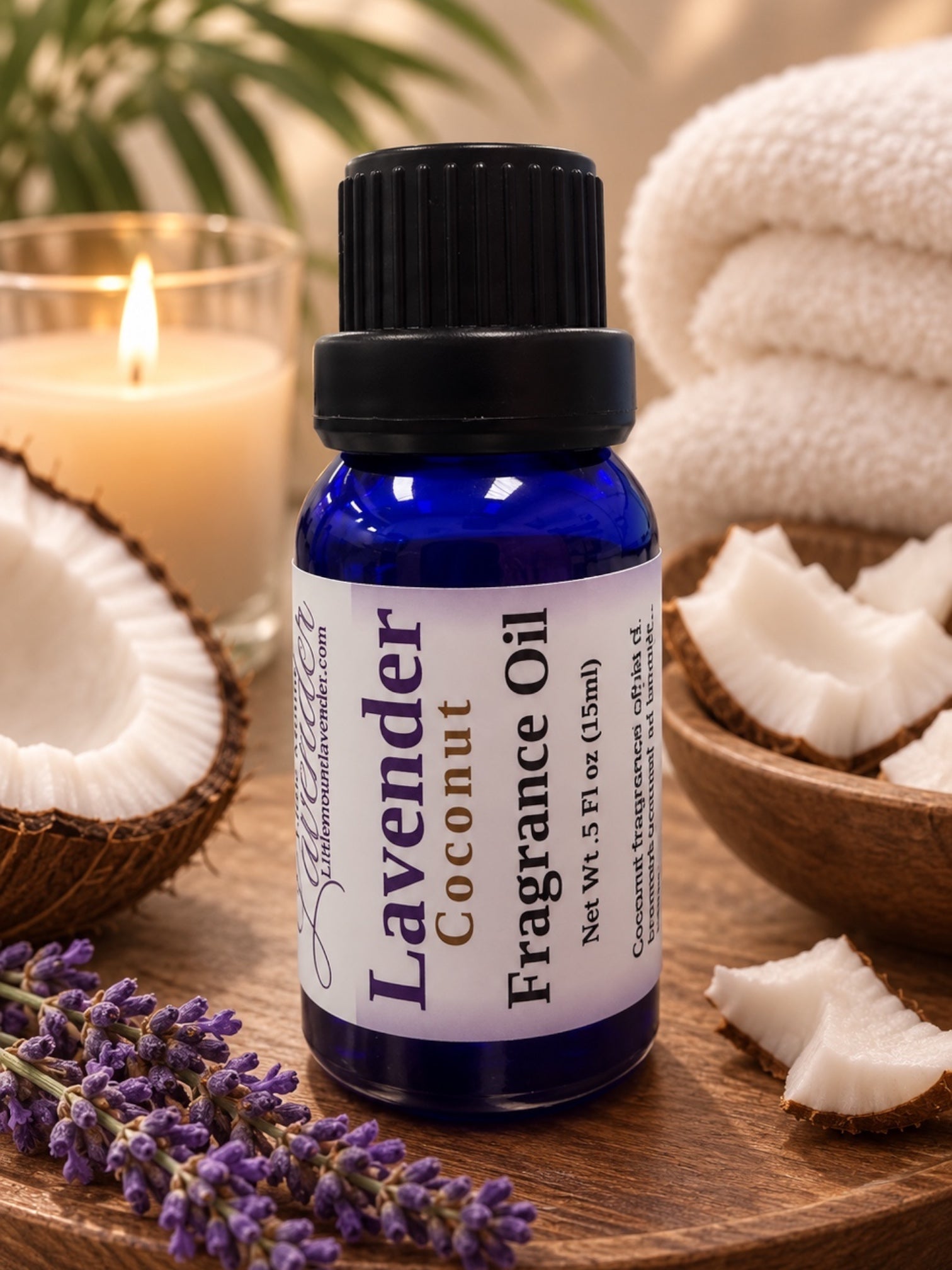 Little Mount Lavender coconut fragrance oil in a deep blue glass bottle with a sprig of fresh lavender flowers