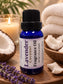 Little Mount Lavender coconut fragrance oil in a deep blue glass bottle with a sprig of fresh lavender flowers