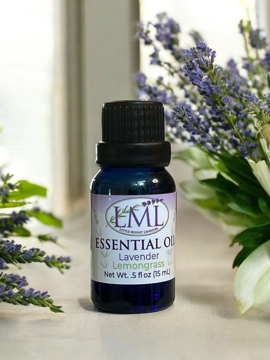 Little Mount Lavender essential oil blend in a blue glass bottle surrounded by fresh lavender flowers.