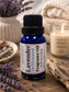 Little Mount Lavender fragrance oil in a cobalt blue glass bottle with fresh lavender sprigs on a cream background.