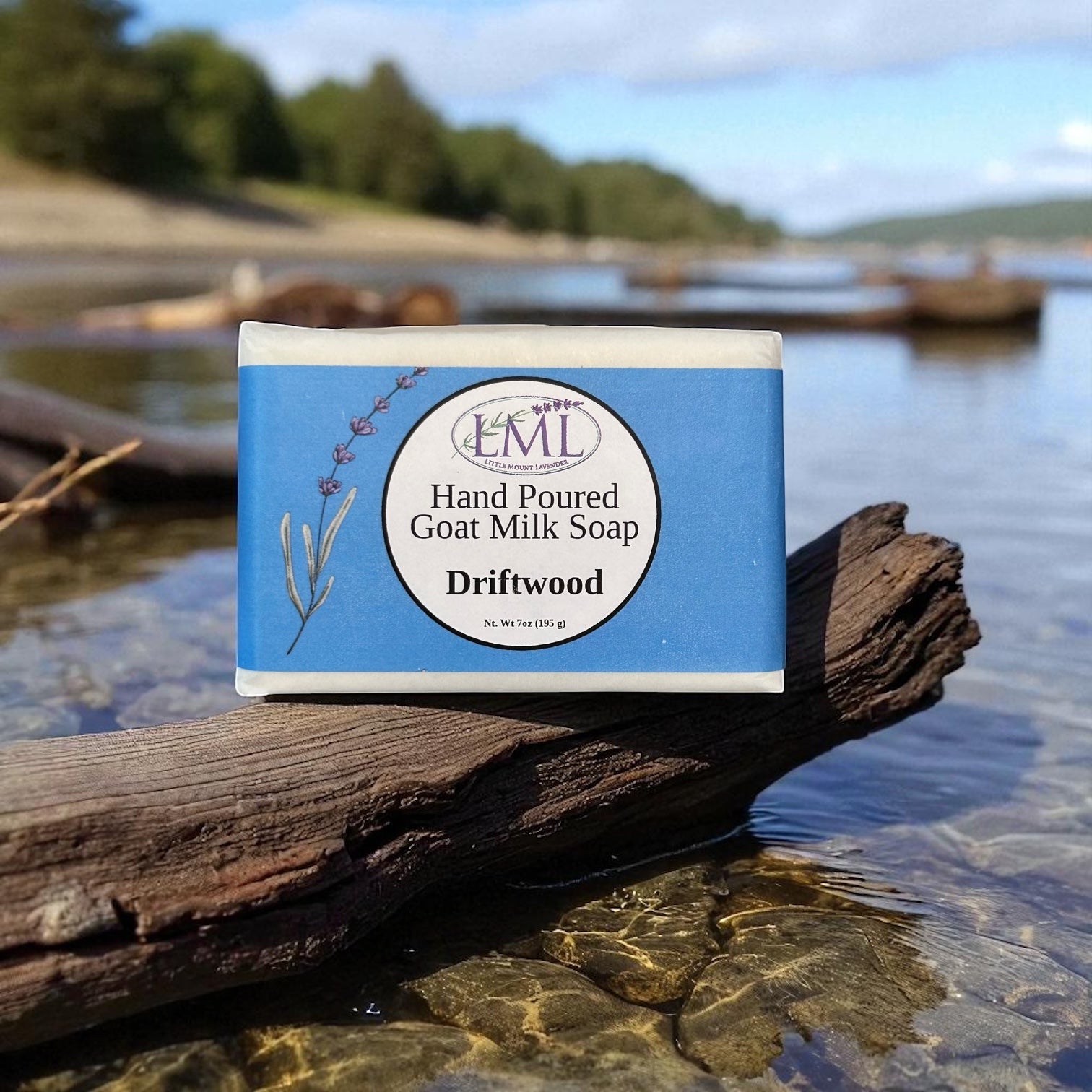 Little Mount Lavender handcrafted goat milk soap with lavender and driftwood scent on a piece of wood by the water.