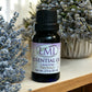 Little Mount Lavender essential oil bottle with lavender and patchouli blend, set against dried lavender flowers.