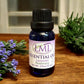 Little Mount Lavender essential oil blend with lavender and rosemary in a blue glass bottle on a wooden surface.