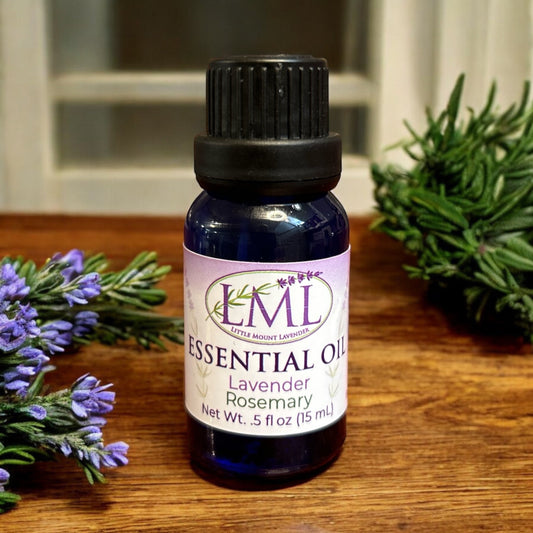 Little Mount Lavender essential oil blend with lavender and rosemary in a blue glass bottle on a wooden surface.