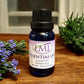 Little Mount Lavender essential oil blend with lavender and rosemary in a blue glass bottle on a wooden surface.