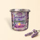 Little Mount Lavender soy candle in a purple glass jar with rosemary and lavender sprigs on a rustic wooden table.