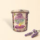 Little Mount Lavender soy candle in a purple glass jar with eucalyptus and lavender scent on a wooden surface.