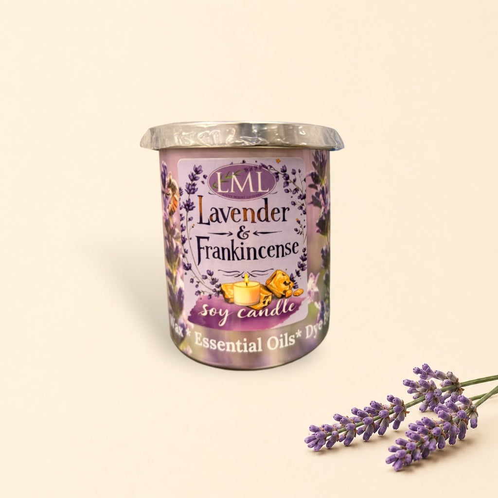 Little Mount Lavender soy candle in a purple glass jar with lavender floral print, surrounded by golden wax melts.