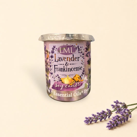 Little Mount Lavender soy candle in a purple glass jar with lavender floral print, surrounded by golden wax melts.