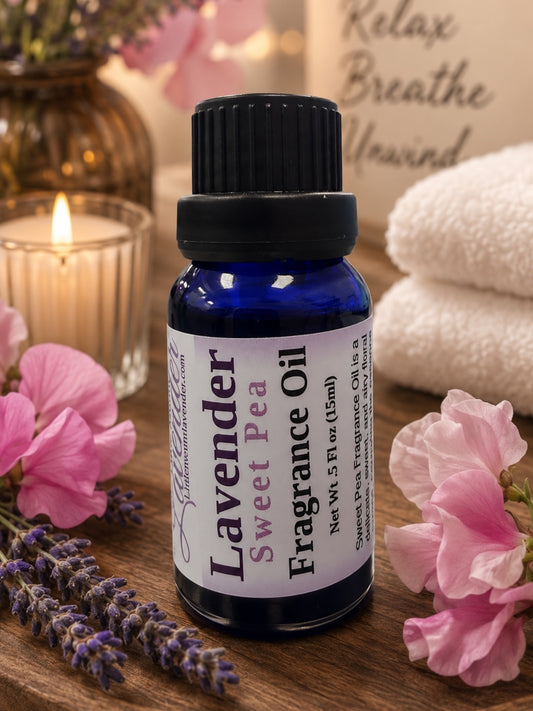Little Mount Lavender Sweet Pea fragrance oil in a cobalt blue glass bottle with fresh lavender sprigs on a beige background
