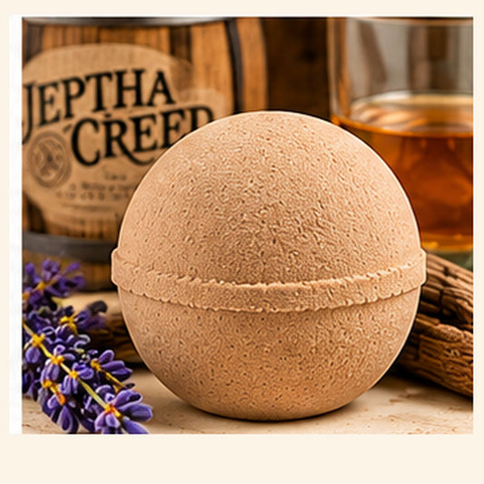 Unwrapped Jeptha Creed Bath Bomb on cream background with natural accents