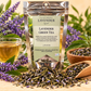 Little Mount Lavender Lavender Green Tea silver pouch with sencha tea, lavender buds and tea cup on warm cream background